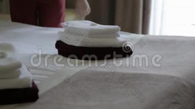酒店：女佣在酒店房间铺床。 酒店服务。 女家政工人，女佣，在客栈铺床
